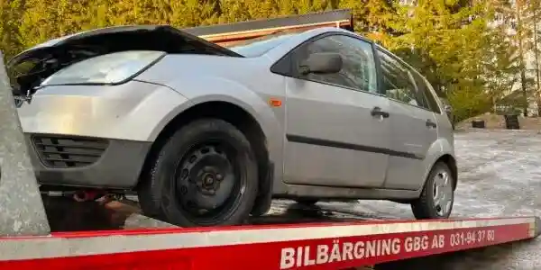 Närbild av motor och komponenter som kontrolleras inför teknisk bedömning av skrotbil